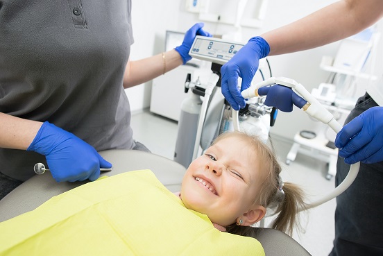 Child getting teeth sealant treatment